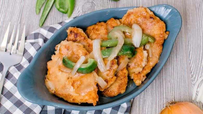 chicken fried pork chops topped with gravy onions and bell peppers