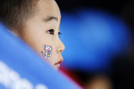 A child wears one of the Olympic mascots on his face when watching the women's 1,500-meter speedskating race at the Gangneung Oval at the 2018 Winter Olympics in Gangneung, South Korea, Feb. 12, 2018. (AP Photo/John Locher)