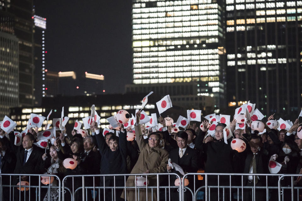 Well-wishers hold Japanese national flags as they cheer during a national festival to celebrate the throne of new emperor at the Imperial Palace in Tokyo Saturday, Nov. 9, 2019. Japanese Emperor Naruhito thanked tens of thousands of well-wishers who gathered outside the palace to congratulate his enthronement at the ceremony organized by conservative political and business groups. (Tomohiro Ohsumi/Pool Photo via AP)