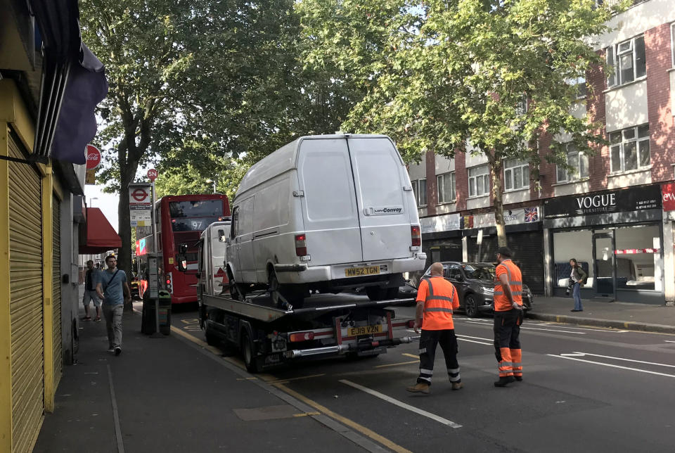 A van, believed to have been driven by the attacker, is loaded at the scene in Leyton, east London, where a police officer was stabbed shortly before midnight after attempting to stop the vehicle.