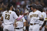 San Diego Padres' Manny Machado, right, is congratulated by Fernando Tatis Jr. (23) after hitting a grand slam against the Atlanta Braves in the fifth inning of a baseball game Saturday, Sept. 25, 2021, in San Diego. (AP Photo/Derrick Tuskan)