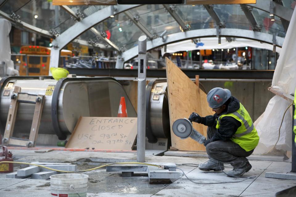 FILE- In this Wednesday, Dec. 14, 2016 file photo, a construction worker cuts stone near an entrance of the unfinished Second Avenue subway in New York. Nearly 45 years after construction began, a long-delayed subway line beneath Manhattan's east side goes into operation on Sunday, Jan. 1, 2017. (AP Photo/Seth Wenig, File)