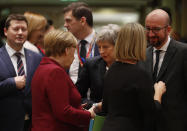 German Chancellor Angela Merkel, center left, speaks with British Prime Minister Theresa May, center, during a round table meeting at an EU summit in Brussels, Thursday, Dec. 13, 2018. EU leaders gathered Thursday for a two-day summit which will center on the Brexit negotiations. (AP Photo/Alastair Grant)