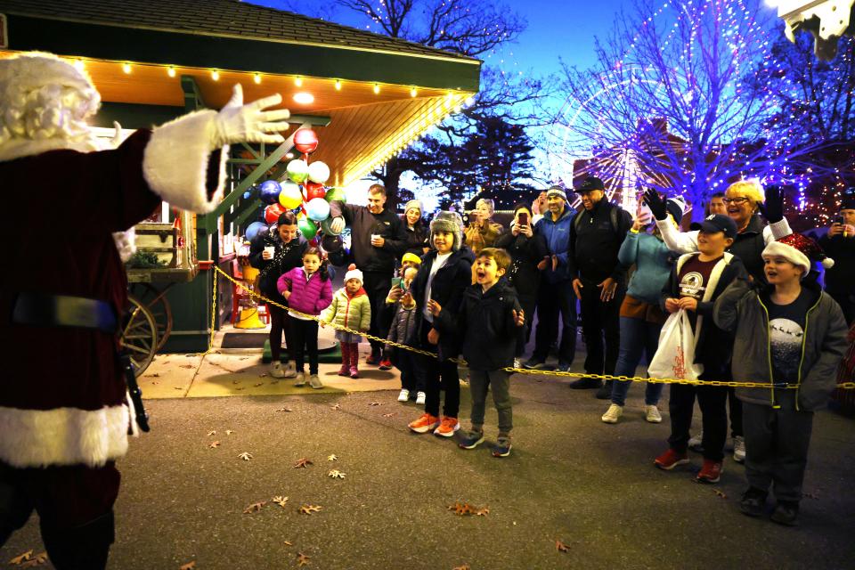 Children react as Santa arrives on a train during Edaville's Christmas Festival of Lights on Thursday, Nov. 19, 2022 at Edaville Family Theme Park in Carver. 