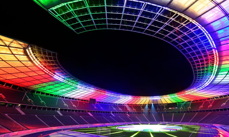 <span>Berlin’s Olympic Stadium is lit up with the colours of the new Euro 2024 logo.</span><span>Photograph: John MacDougall/AFP/Getty Images</span>