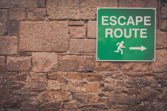 A sign posted on a wall that reads: "Escape Route"