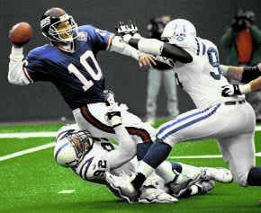 New York\'s Kent Graham tries to get rid of the ball as he is hit by Indianapolis\' Chad Bratzke (92) and Shawn King during Sunday\'s game at East Rutherford, N.J. The Colts won 27-19. AP Photo