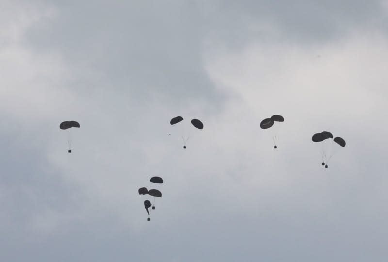 Humanitarian aid packages land by the help of parachutes after dropping from a plane as Israeli attacks continue in Gaza City. Ali Hamad/APA Images via ZUMA Press Wire/dpa