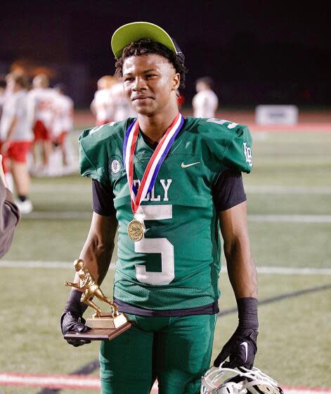 Poly receiver Kamarie Smith with his game MVP trophy after catching three touchdown passes.