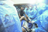 One of the persons injured after an Air India Express flight skidded off a runway while landing at the Kozhikode airport is brought for treatment to the Medical College Hospital in Kozhikode, Kerala state, India, Friday, Aug. 7, 2020. (AP Photo)