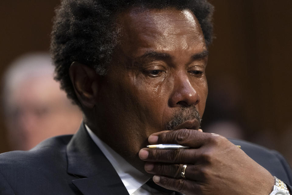 FILE - Garnell Whitfield, Jr., of Buffalo, N.Y., whose mother, Ruth Whitfield, was killed in the Buffalo Tops supermarket mass shooting, wipes away tears as he testifies at a Senate Judiciary Committee hearing on domestic terrorism on June 7, 2022, on Capitol Hill in Washington. As mass shootings are again drawing public attention, states across the U.S. seem to be deepening their political divide on gun policies. A series of recent mass shootings in California come after a third straight year in which U.S. states recorded more than 600 mass shootings involving at least four deaths or injuries. (AP Photo/Jacquelyn Martin, File)