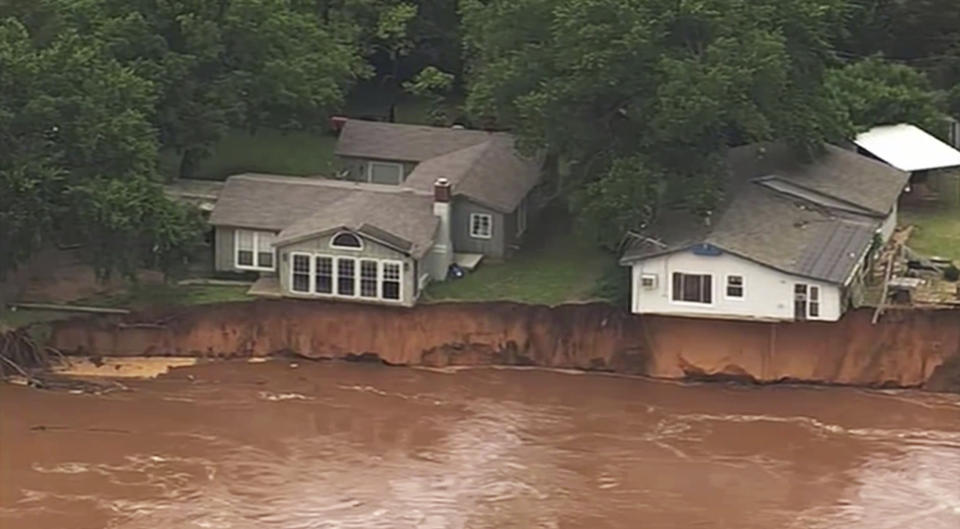 This image taken from video provided by KOCO-5 shows homes dangerously close to the Cimarron River on Wednesday, May 22, 2019 near Crescent, Oka. Waterlogged parts of the central U.S. were bracing Wednesday for more rain, following days of severe storms that have battered Iowa, Kansas, Missouri and Oklahoma. (KOCO-5 via AP)