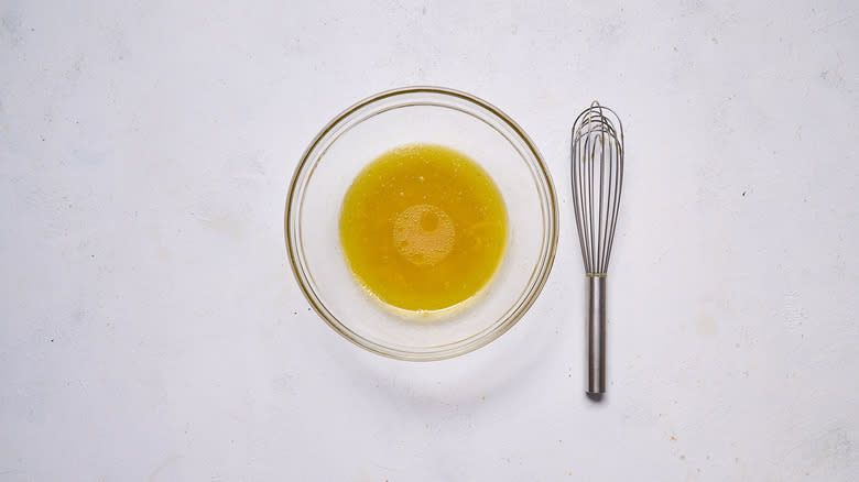 yuzu olive oil dressing in bowl with whisk