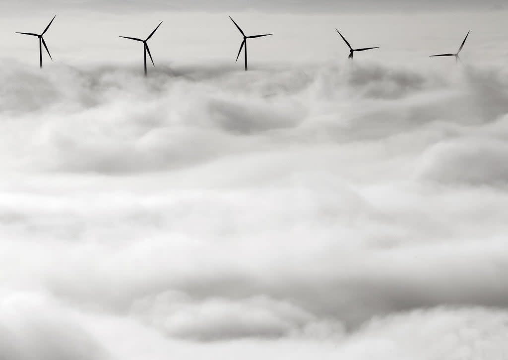 Wind turbines stand out from a dense blanket of fog covering Pamplona, northern Spain (EPA)