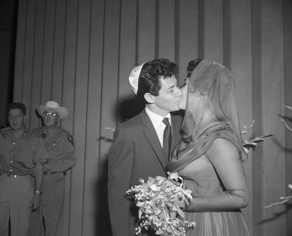 Singer Eddie Fisher kisses his new bride, actress Elizabeth Taylor, after they were married at a Jewish Temple here May 12.