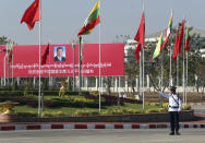 FILE - In this Jan. 17, 2020, file photo, a traffic police stands on a road as he clears a road near a welcoming billboard to Chinese President Xi Jinping, in Naypyitaw, Myanmar. The military coup on Monday, Feb. 1, 2021 deposed national leader Aung San Suu Kyi a little over a year after Xi made a show of support to her with the first visit by a head of state from Beijing to Myanmar since 2001 and 33 agreements on a wide range of issues. (AP Photo/Aung Shine Oo, File)