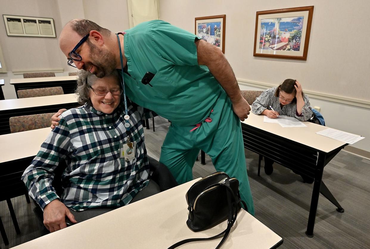 As her daughter Karen, who has Down syndrome, fills out forms, Marilyn Kent is greeted by Dr. Jason Kass, an ear, nose and throat surgeon affiliated with St. Vincent Hospital.