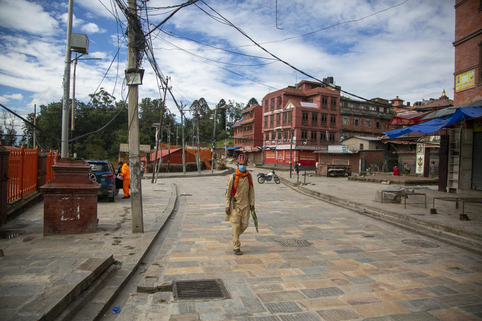 A Nepalese Hindu Priest walks at the deserted Pashupatinath temple premises during Teej festival in Kathmandu, Nepal, Friday, Aug. 21, 2020. Autumn is the festival season in predominantly Hindu Nepal, where religion, celebrations and rituals are big parts of lives, but people this year will have to scale down their rituals within their homes. (AP Photo/Niranjan Shrestha)