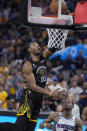 Golden State Warriors forward Jonathan Kuminga (00) scores against Sacramento Kings guard De'Aaron Fox during the second half of Game 3 of an NBA basketball first-round playoff series in San Francisco, Thursday, April 20, 2023. (AP Photo/Jeff Chiu)