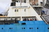 Crew members stand aboard the Akademik Alexander Karpinsky, a Russian polar explorer ship as it arrives in Cape Town