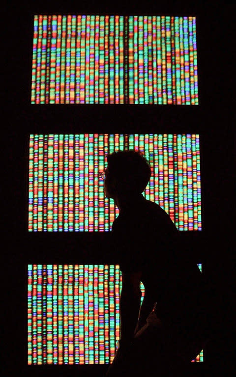 A man walks past a digital representation of the human genome - Credit: Getty