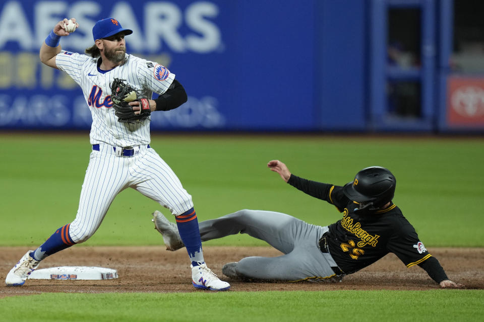 New York Mets second base Jeff McNeil, left, turns a double play over Pittsburgh Pirates' Alika Williams during the third inning of a baseball game at Citi Field, Tuesday, April 16, 2024, in New York. (AP Photo/Seth Wenig)