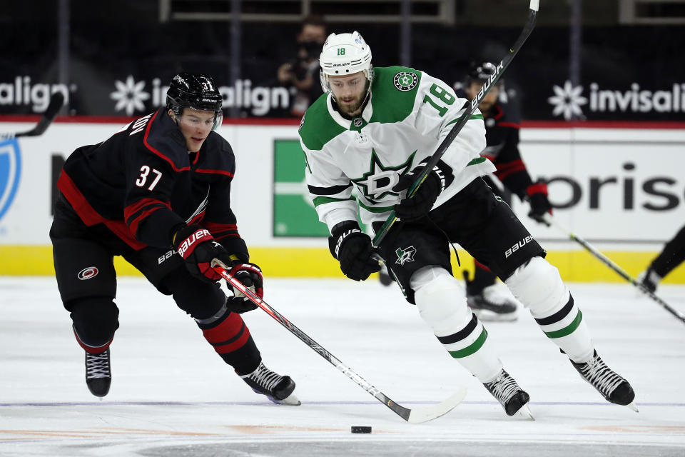 Carolina Hurricanes' Andrei Svechnikov (37) reaches for the puck controlled by Dallas Stars' Jason Dickinson (18) during the third period of an NHL hockey game in Raleigh, N.C., Saturday, Jan. 30, 2021. (AP Photo/Karl B DeBlaker)