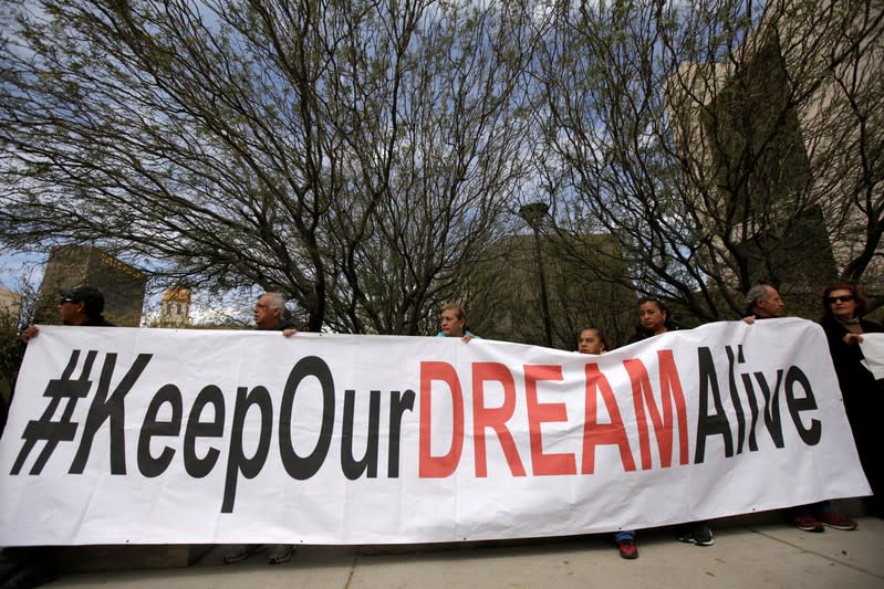 Members of the Border Network for Human Rights and Borders Dreamers and Youth Alliance hold a banner during protest to demand that Congress pass a Clean Dream Act in El Paso