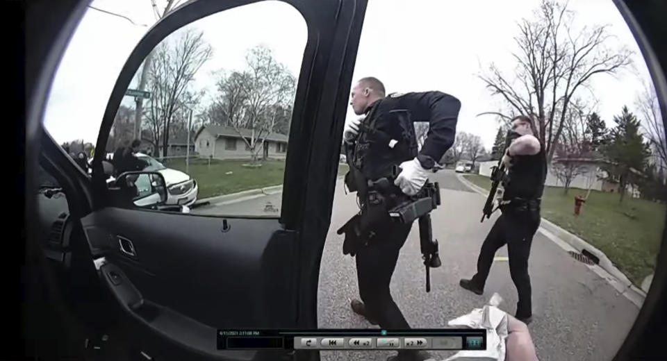 CORRECTS TO BODY CAM OF BROOKLYN CENTER POLICE OFFICER JEFFREY SOMMERS, NOT CHAMPLIN POLICE OFFICER DANIEL IRISH - In this image taken from Brooklyn Center Police Officer Jeffrey Sommers' police body cam video that was played during the trial of former Brooklyn Center police Officer Kim Potter on Thursday, Dec. 9, 2021, in Minneapolis, police approach the car that Daunte Wright was driving after being shot during a traffic stop. Potter, who is white, is charged with first- and second-degree manslaughter in the shooting of Wright, a Black motorist, in the suburb of Brooklyn Center. Potter has said she meant to use her Taser – but grabbed her handgun instead – after Wright tried to drive away as officers were trying to arrest him. (Court TV, via AP, Pool)