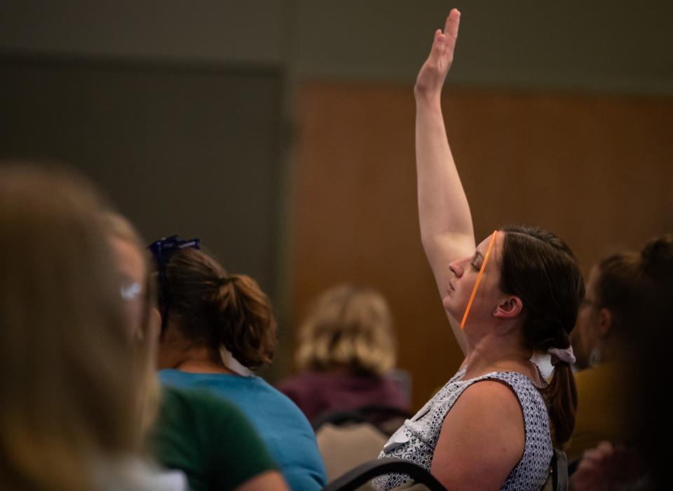 An attendee raises her hand during a presentation at Encompass' all-staff professional development day on Aug. 25.