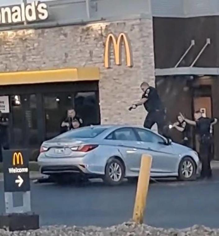 Bystander video shows a Georgetown police officer standing on the hood of a car after multiple officers opened fire on a suspect in an attempted car theft. Photo via Kentucky State Police investigation documents