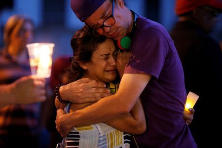 People embrace during a vigil for Abdirahman Abdi, a Somali immigrant to Canada who died after being hospitalized in critical condition following his arrest by Canadian police, in Ottawa, Ontario, Canada, July 26, 2016. REUTERS/Chris Wattie