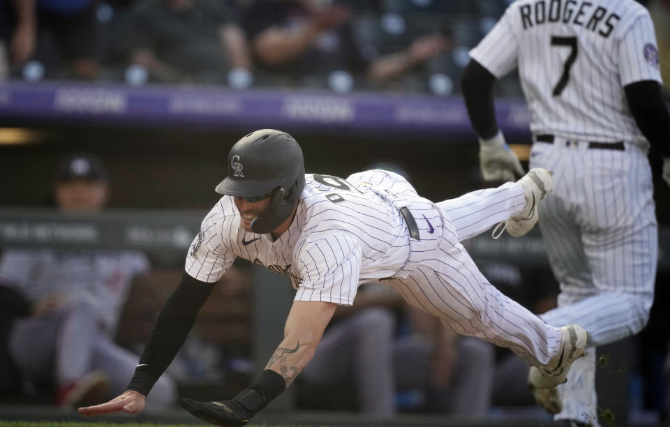 Colorado Rockies' Brenton Doyle, left, slides safely into home plate to score the winning run on a wild pitch by Minnesota Twins relief pitcher Jordan Luplow in the 11th inning of a baseball game Sunday, Oct. 1, 2023, in Denver. (AP Photo/David Zalubowski)