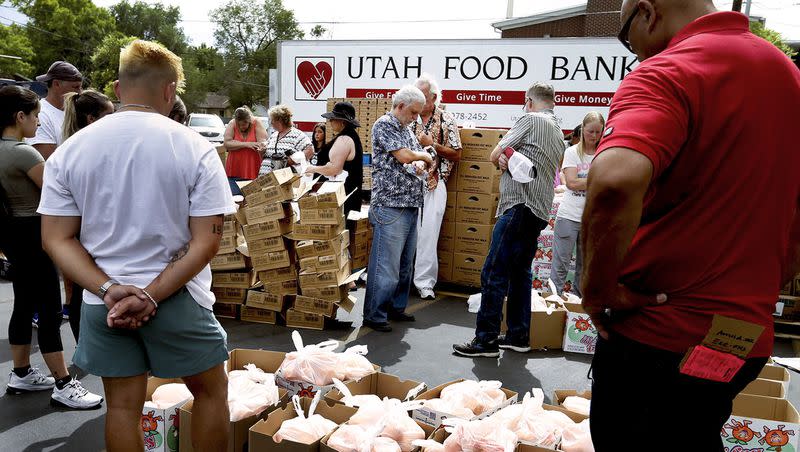 Volunteers pray before handing out food at the Utah Food Bank mobile pantry at The Church of Jesus Christ of Latter-day Saints Cannon Stake Center in Salt Lake City on June 9, 2021.