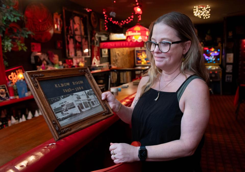 Co-owner Lesa Touchette shows a vintage photo of the original location of the Elbow Room in Pensacola on Friday, Sept. 29, 2023. The Elbow Room is celebrating its 60th anniversary.