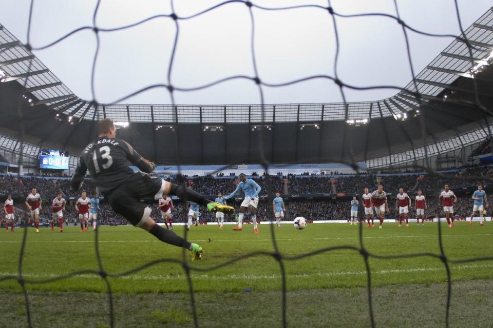 Manchester City's Yaya Toure, centre, scores a penalty past Fulham's goalkeeper David Stockdale during their English Premier League soccer match at the Etihad Stadium, Manchester, England, Saturday March 22, 2014. (AP Photo/Jon Super)