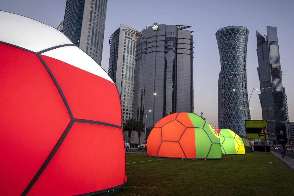FILE - Domes featuring different national colors are displayed near the Doha Exhibition and Convention Center where soccer World Cup draw will be held, in Doha, Qatar, Thursday, March 31, 2022. Hosting the World Cup marks a pinnacle in Qatar's efforts to rise out of the shadow of its larger neighbors in the wider Middle East. (AP Photo/Darko Bandic, File)