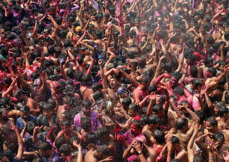 Men daubed in colours dance during Holi celebrations in Prayagraj, India, March 21, 2019. REUTERS/Jitendra Prakash