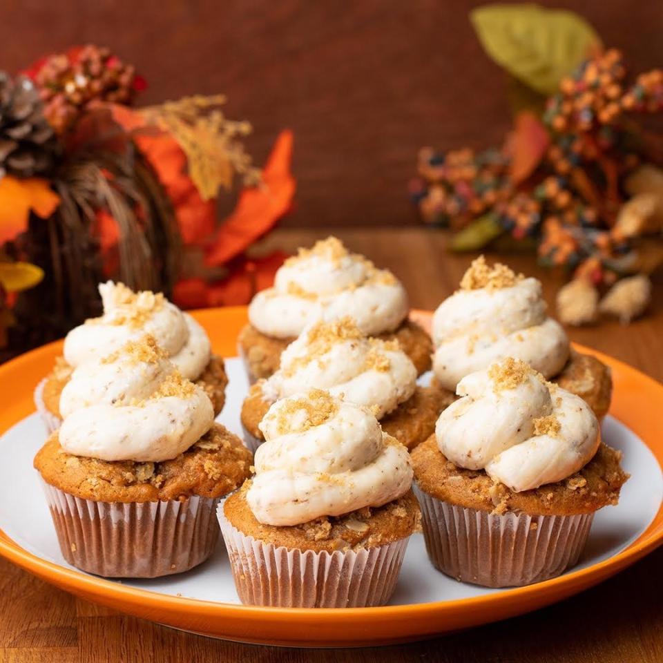 Plate of seven pumpkin cupcakes topped with a dollop of  marshmallow fluff sprinkled with crushed crackers