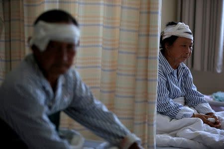 Jiang Xiuqing (R), 65, who was injured when a tornado hit Funing on Thursday, sits at a hospital in Yancheng, Jiangsu province, June 25, 2016. REUTERS/Aly Song