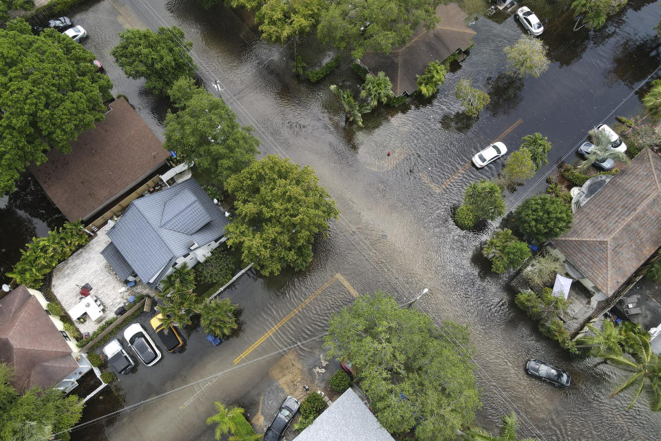 FILE - A pair of waterlogged cars sit abandoned in the road as floodwaters recede in the Sailboat Bend neighborhood of Fort Lauderdale, Fla., April 13, 2023. The Biden administration on Thursday, April 11, 2024, awarded $830 million in grants to fund 80 projects aimed at toughening the nation's aging infrastructure against the harmful impacts of climate change. (AP Photo/Rebecca Blackwell, File)