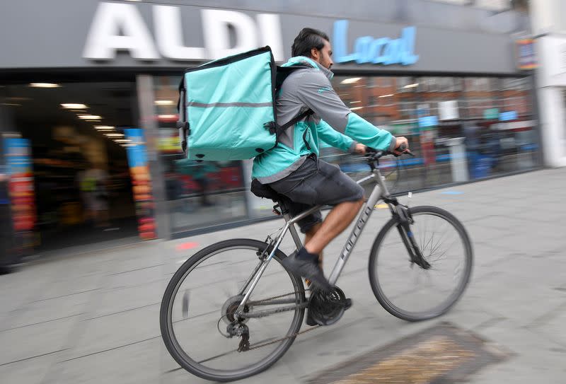 FILE PHOTO: Abdelaziz Abdou, a Deliveroo delivery rider, poses with a bag of Aldi groceries, London, Britain