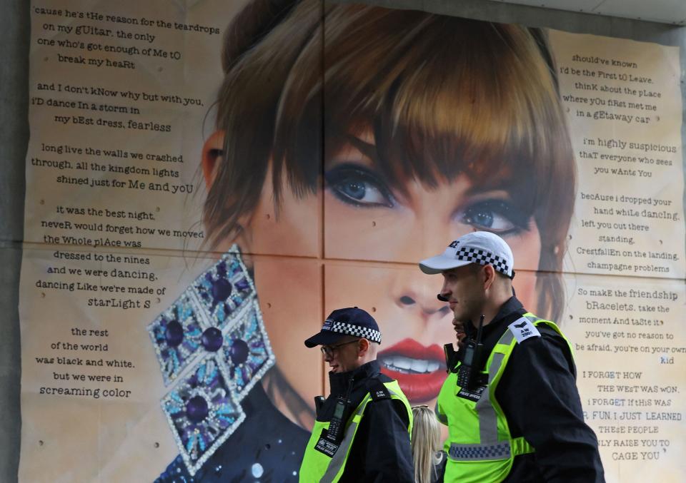 Police officers walk past a mural of Taylor Swift while on duty for the Community Shield football match at Wembley Stadium in London