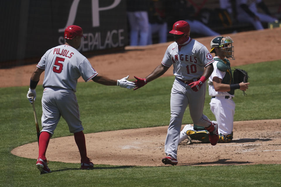 Los Angeles Angels' Justin Upton (10) is congratulated by Albert Pujols after hitting a solo home run against the Oakland Athletics during the fourth inning of a baseball game in Oakland, Calif., Saturday, July 25, 2020. Athletics catcher Austin Allen, right, looks on. (AP Photo/Jeff Chiu)