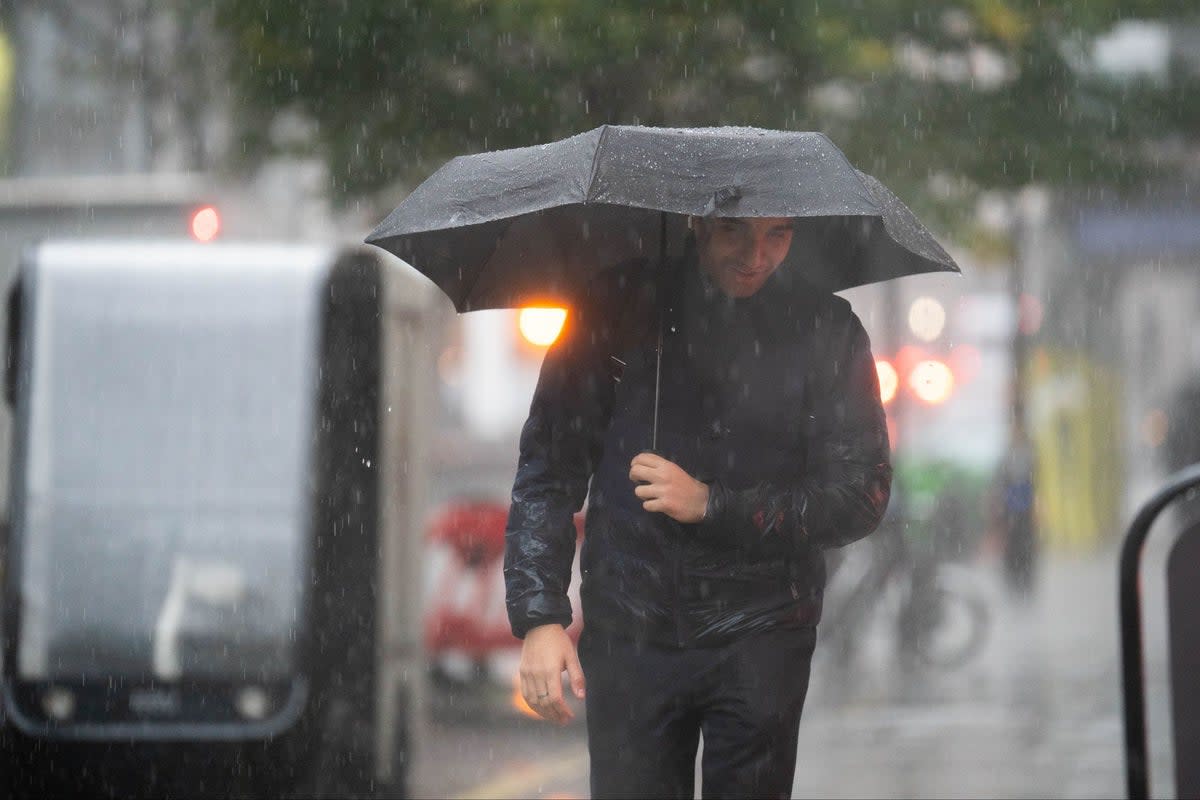 People walk in the rain near the Home Office on Tuesday (PA)