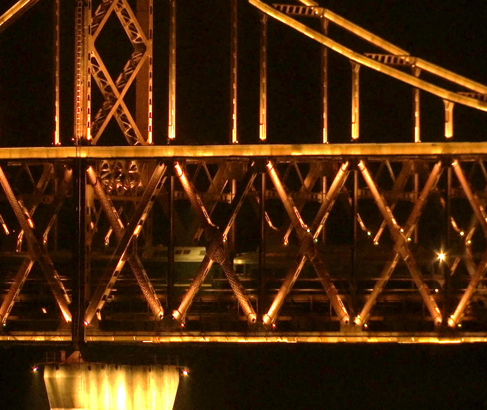 In this image taken from video footage, a train similar to ones seen during previous visits to China by North Korean leader Kim Jong Un crosses the Friendship Bridge from North Korea into China as seen from Dandong in northeastern China's Liaoning Province, Saturday, Feb. 23, 2019. A train similar to one used in the past by Kim Jong Un entered China on Saturday evening, possibly carrying the North Korean leader on a journey to Vietnam's capital for his summit with President Donald Trump. (AP Photo/Dake Kang)