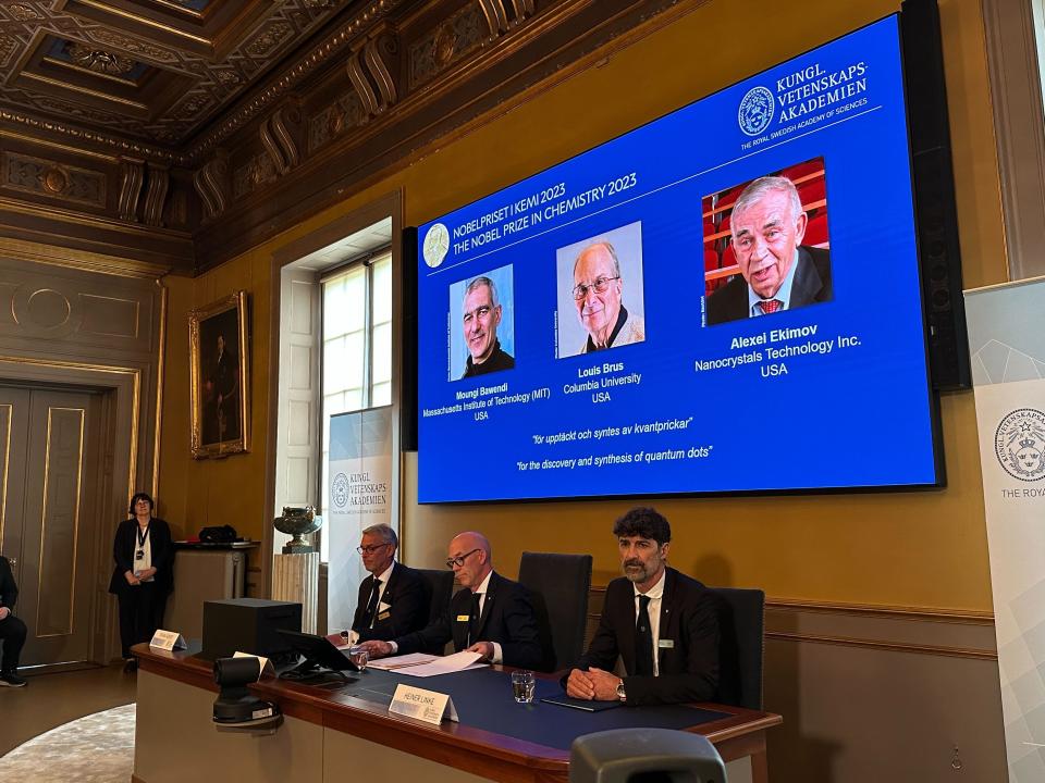 Auf der Projektion während der Bekanntgabe des Nobelpreises für Chemie sind die Wissenschaftler Moungi Bawendi (l-r), Louis Brus und Alexei Ekimov zu sehen. (Bild: Steffen Trumpf/dpa)