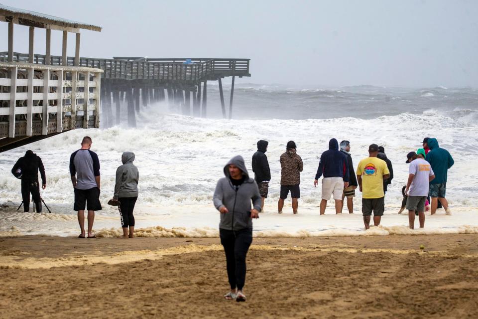 People gather to watch the waves during Hurricane Dorian at the Virginia Beach Fishing Pier.