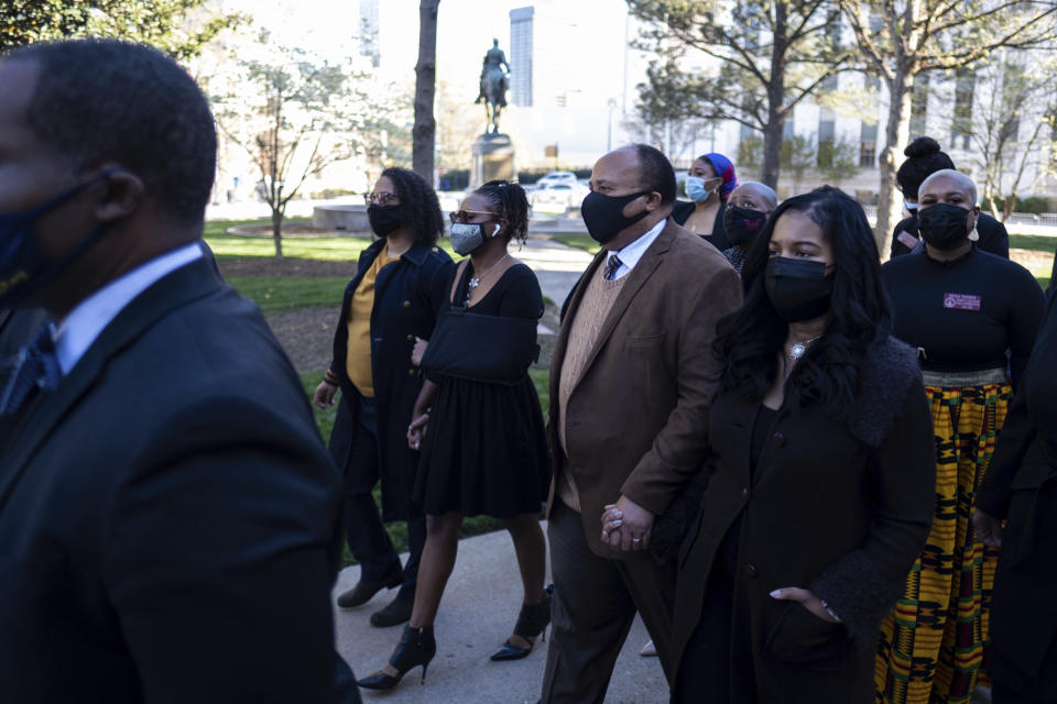 FILE - In this Monday, March 29, 2021 file photo, Georgia State Rep. Park Cannon, D-Atlanta,, center with arm in sling, walks beside Martin Luther King, III, as she returns to the State Capitol in Atlanta after being arrested last week for knocking on the governor's office door as he signed voting legislation. In Georgia, faith leaders are asking corporate executives to condemn laws restricting voting access — or face a boycott. In Arizona and Texas, clergy have assembled outside the state capitols to decry what they view as voter-suppression measures targeting Black and Hispanic people.(AP Photo/Ben Gray)