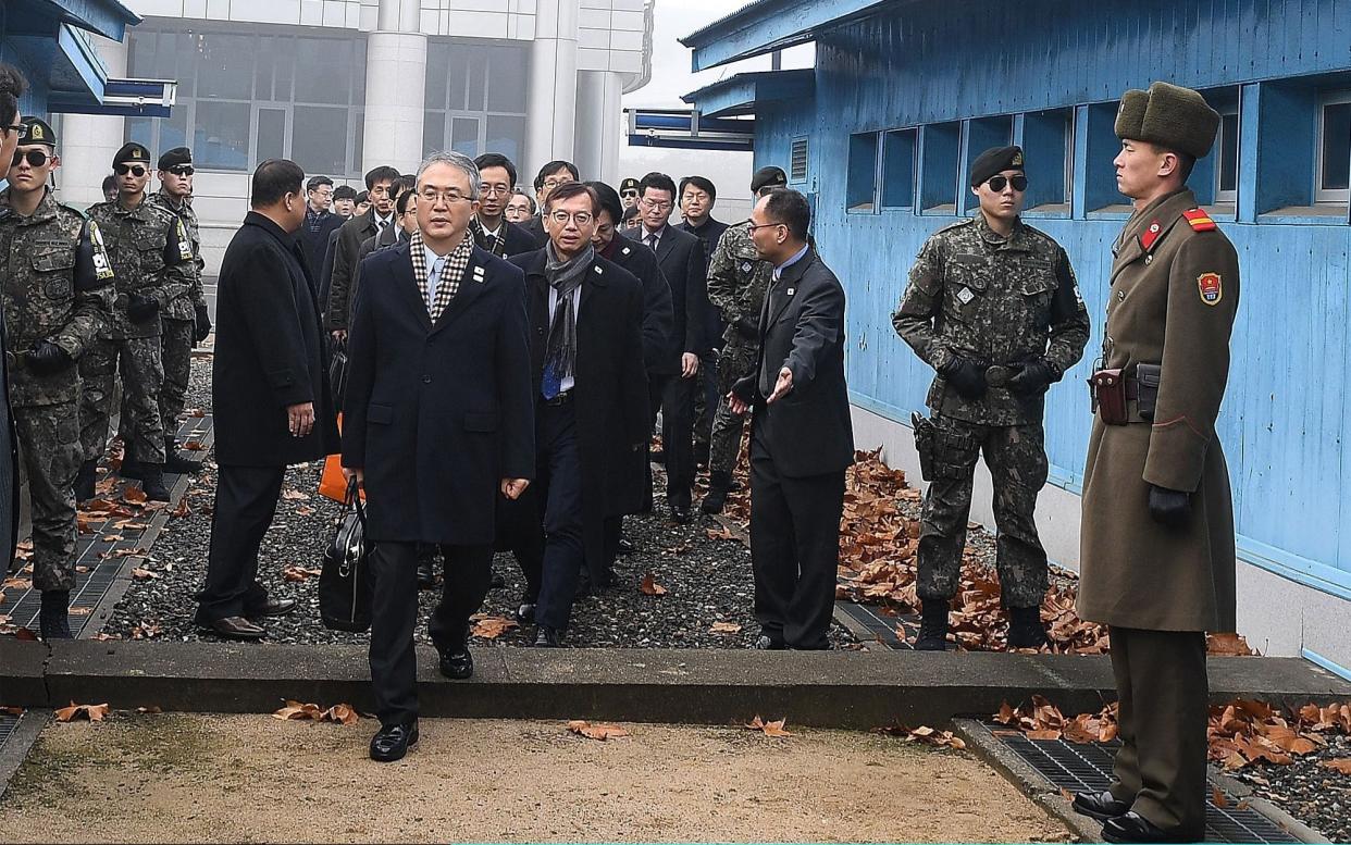 In this handout image provided by the South Korean Unification Ministry, the head of South Korean delegation Lee Woo-sung, front, crosses to the North Korea side for the meeting on Monday - Getty Images AsiaPac